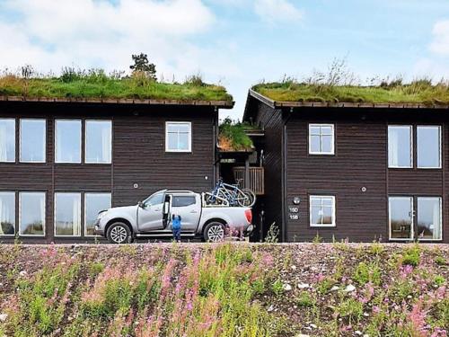 a truck parked in front of a house with a grass roof at 8 person holiday home in S LEN in Stöten