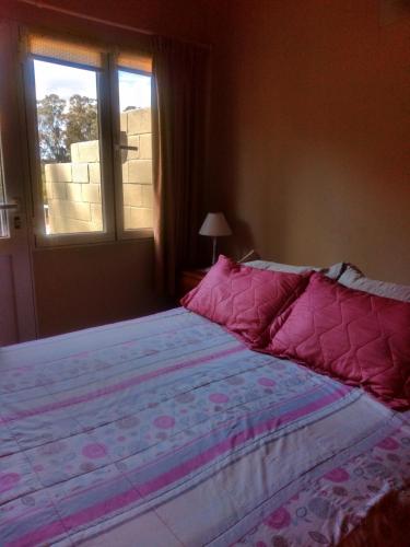 a large bed in a bedroom with a window at La Casa de Liber in Tandil