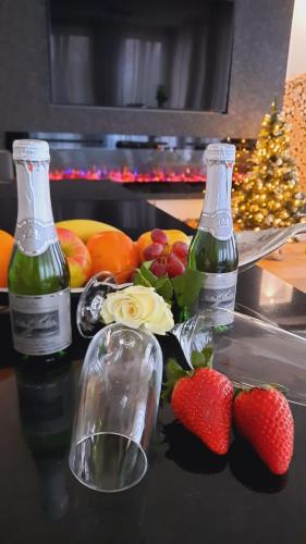 two bottles of wine and strawberries on a table at Viktoria Deluxe direkter Meerblick in Ostseebad Sellin