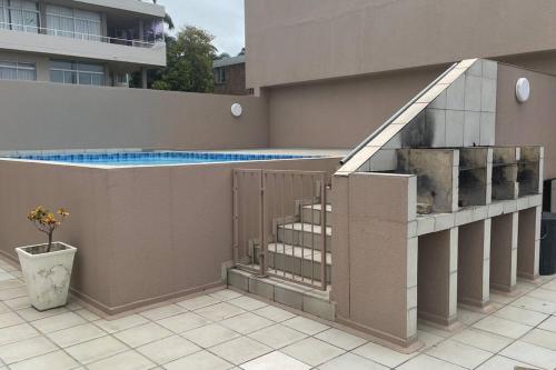 un edificio con piscina y parrilla en Cerf@BeachFront, en Margate