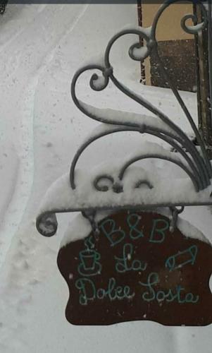 a sign in the snow with a sign on it at B&B La Dolce Sosta in Fonni