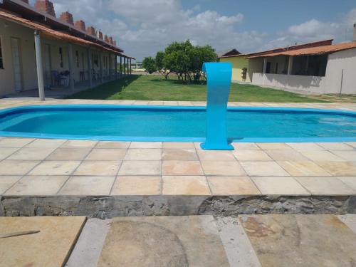 a pool with a blue pole next to a house at Pousada Rota das Dunas de Amaro in Santo Amaro