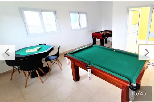 ein Billardtisch in einem Raum mit einem Tisch und einem Stuhl in der Unterkunft Vila Monrealle in Ubatuba