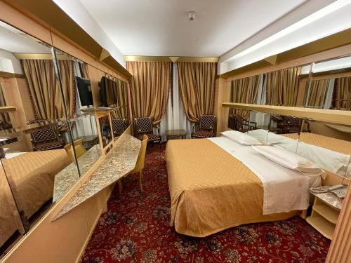 Habitación de hotel con 2 camas y espejo en Hotel Wagner, en Milán