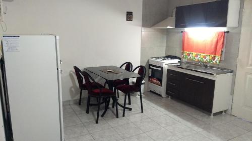 Villa RosaにあるEstudio Norte Pilarのキッチン(テーブル、椅子、冷蔵庫付)