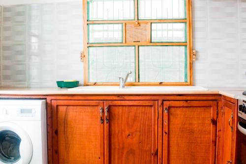 a kitchen with a sink and a window at Ya Aluga Apartment - Serekunda in Serekunda