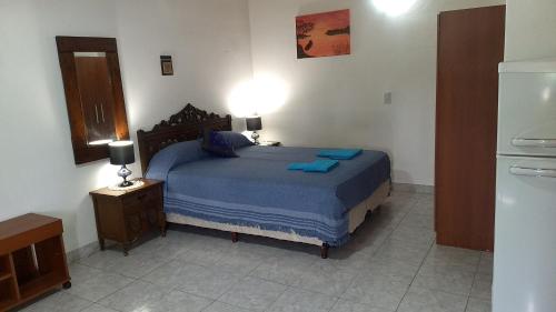 Villa RosaにあるEstudio Norte Pilarのベッドルーム1室(青いシーツ付きのベッド1台、冷蔵庫付)