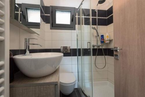 a bathroom with a sink and a glass shower at Το σπίτι δίπλα από το ποτάμι in Tríkala