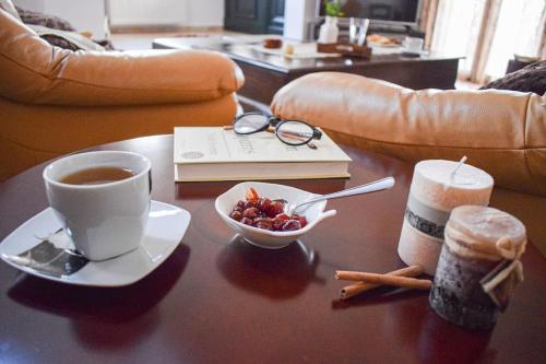 a coffee table with a cup of coffee and a bowl of fruit at Rahati Holiday Villa Maisonette by Estia in Kerásia