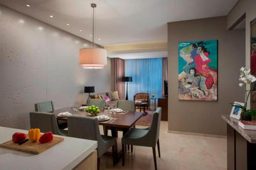 a dining room and living room with a table and chairs at Ascott Kuningan Jakarta in Jakarta