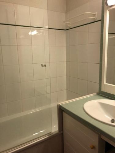 une salle de bain blanche avec une douche et un lavabo dans l'établissement Pied des pistes, lumineux 4p, parking couvert, à La Mongie