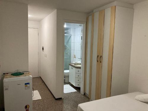 Cette chambre comprend une salle de bains pourvue d'un évier et d'un réfrigérateur. dans l'établissement 104 Apart mobiliado vista mar Praia de Iracema, à Fortaleza