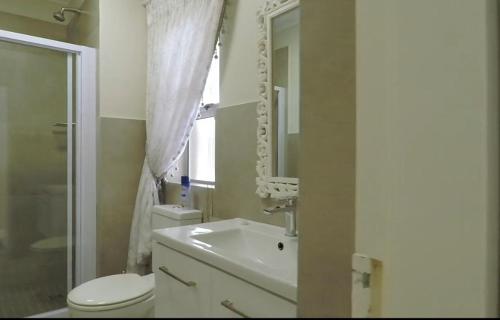 y baño con lavabo, aseo y espejo. en Century City Mayfair Luxury Apartments, en Ciudad del Cabo