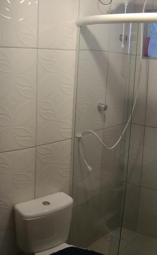 a bathroom with a toilet and a glass shower at Casa barreto in Florianópolis