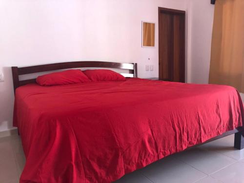 a red bed with a red blanket on it at Hotel Villa Diamante in Xpujil