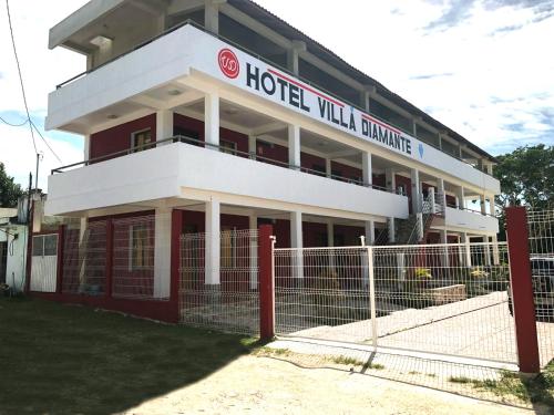 a hotel building with a fence in front of it at Hotel Villa Diamante in Xpujil