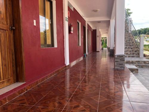 an empty hallway of a building with red walls at Hotel Villa Diamante in Xpujil