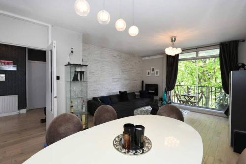 sala de estar con mesa, sillas y sofá en Superb 3 bed flat with balcony in St John's Wood en Londres