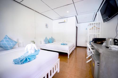 a room with two beds and a tv in it at Assava Dive Resort - SHA Plus in Koh Tao
