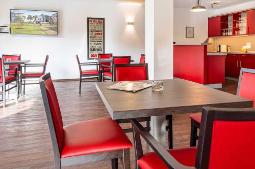 a dining room with a table and red chairs at Terrassenwohnung "Usedom" - Oase am Haff in Garz-Usedom