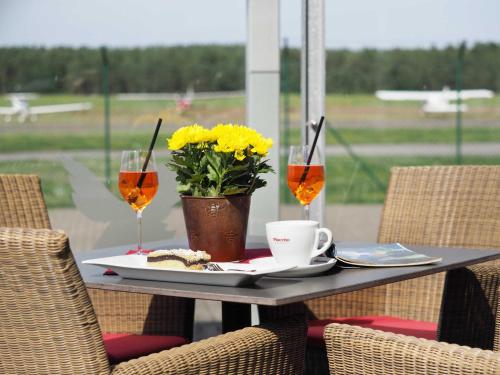 a table with a plate of food and two wine glasses at Terrassenwohnung "Usedom" - Oase am Haff in Garz-Usedom