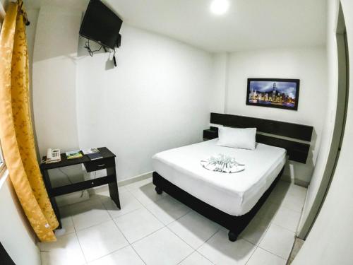 a small bedroom with a bed and a night stand at HOTEL BLACK & WHITE in Cali