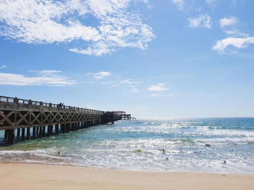 a pier on the beach next to the ocean at APA-TREE Boutique Hotel in Natai Beach