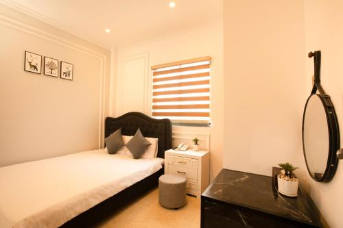 a small bedroom with a bed and a mirror at Phước Hưng 2 Hotel in Vĩnh Long