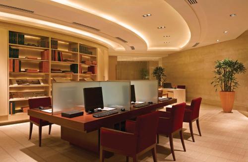 an office with a long desk with chairs and a computer at Trident Bandra Kurla in Mumbai