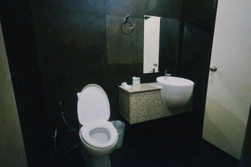 La salle de bains est pourvue de toilettes blanches et d'un lavabo. dans l'établissement Rabeang Bann Koh Samed ระเบียงบ้านเกาะเสม็ด, à Ko Samet