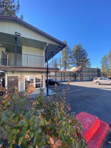 a building in a parking lot with a bush in front of it at Budget INN At The Heavenly Gondola in South Lake Tahoe