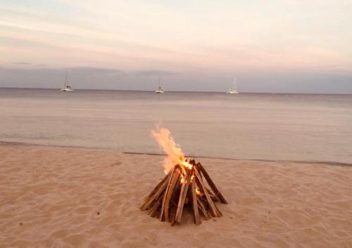 a bonfire in the sand on a beach at Trinco Beach by DSK in Trincomalee