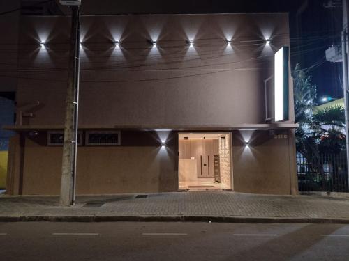 a building with a door on a street at night at Piemont Hotel in Curitiba