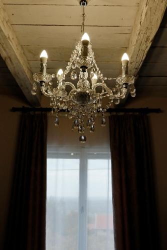 a chandelier hanging from a ceiling with a window at Smaragd in Doba