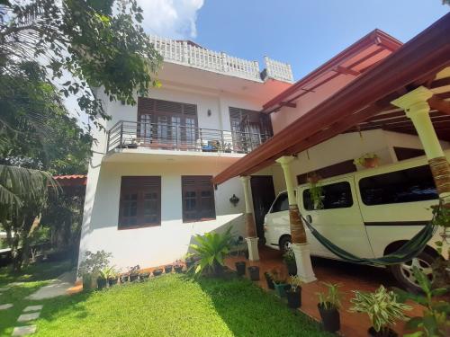 a white house with a van parked outside of it at Abinu"s Place in Dickwella