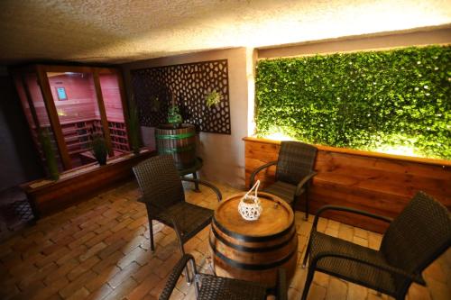 a patio with chairs and a table and a green wall at Rubin in Doba