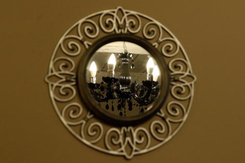 a mirror hanging on a wall with a chandelier at Rubin in Doba