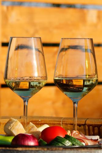 two glasses of wine sitting on a tray with vegetables at Rubin in Doba