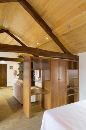 a bedroom with a bed and a wooden ceiling at Caxila Apartamentos Rurales - Luarca - Asturias in Setienes