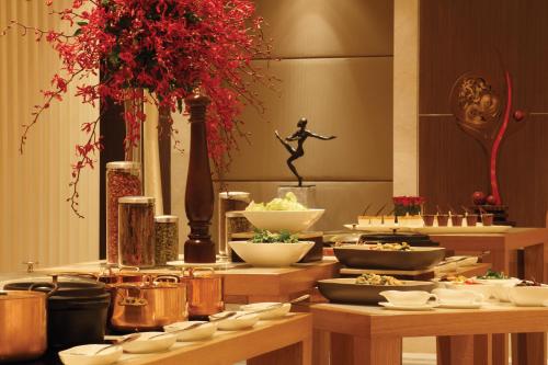 a buffet with bowls of food on wooden tables at Trident Bandra Kurla in Mumbai