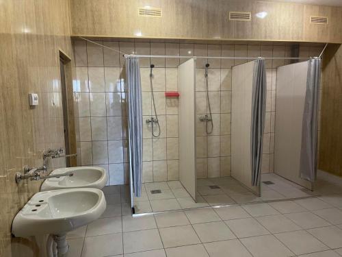 uma casa de banho com 2 lavatórios e um chuveiro em От заката до рассвета em Poltava