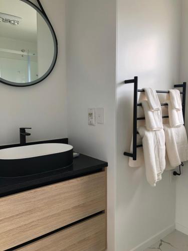 a bathroom with a sink and a mirror at Comfortable Holiday Home at Mt Wellington in Auckland