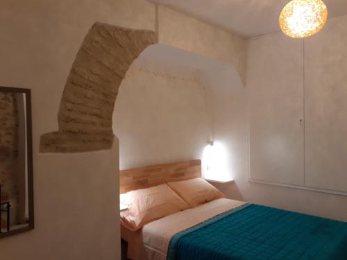a bedroom with a bed with a stone archway at Domus San Francesco in Assisi