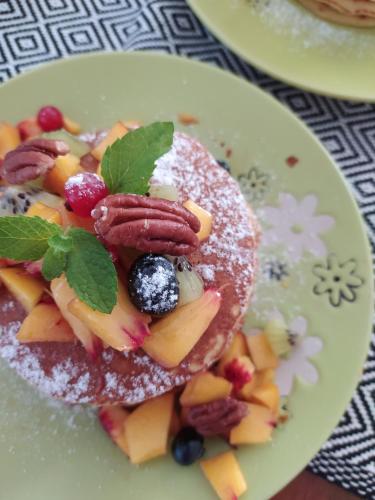 a plate with a pancake with fruit on it at Il Sentiero B&Bìo in SantʼAntìoco