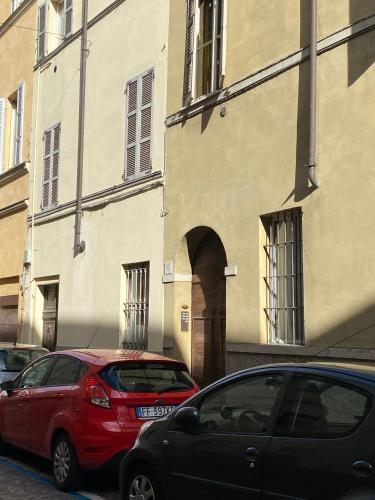 two cars parked in front of a building at Parma Centro House in Parma