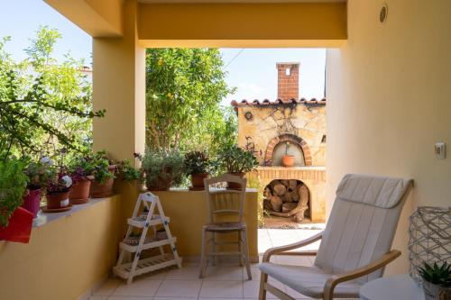 a patio with two chairs and a fireplace at Μονοκατοικία στο Παλιόκαστρο in Palaiokastro