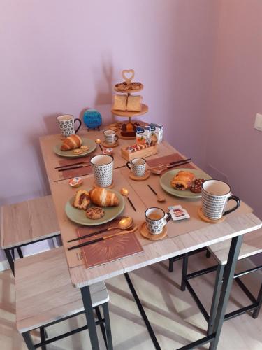 una mesa con platos de repostería y tazas de café en B&B San Francesco en Asís