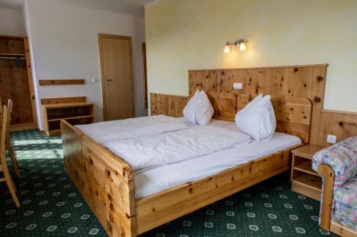 a bedroom with a wooden bed in a room at Gasthof Dreiländereck in Schwarzenberg am Bohmerwald