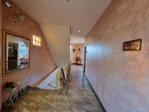 a hallway of a house with a staircase and a mirror at Kireeya Villa in Phetchaburi