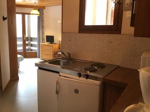 uma cozinha com um lavatório e um fogão forno superior em Chalet les arolles em Les Orres